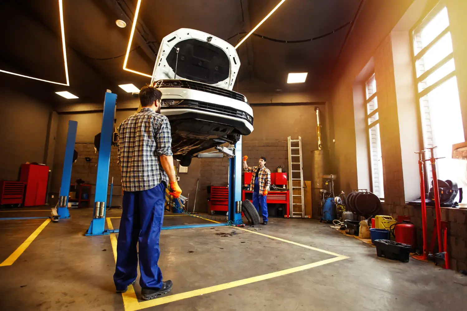 Professional auto repair workshop in Kuwait with mechanics working on a car service.