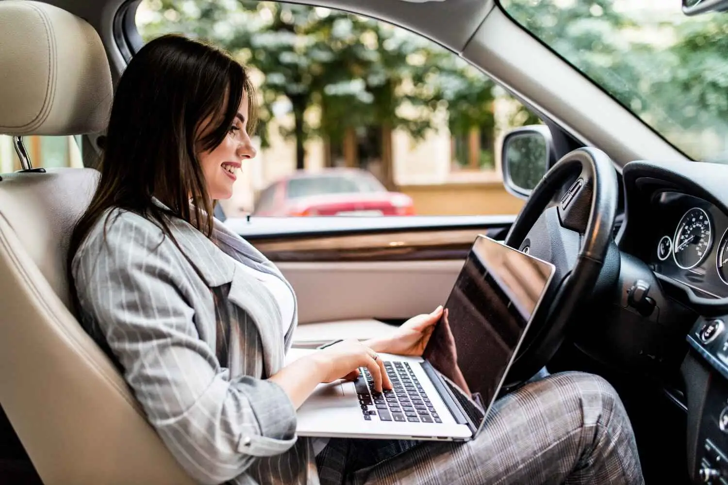  Smiling woman booking oil change service in Kuwait online from car for fast and reliable maintenance.