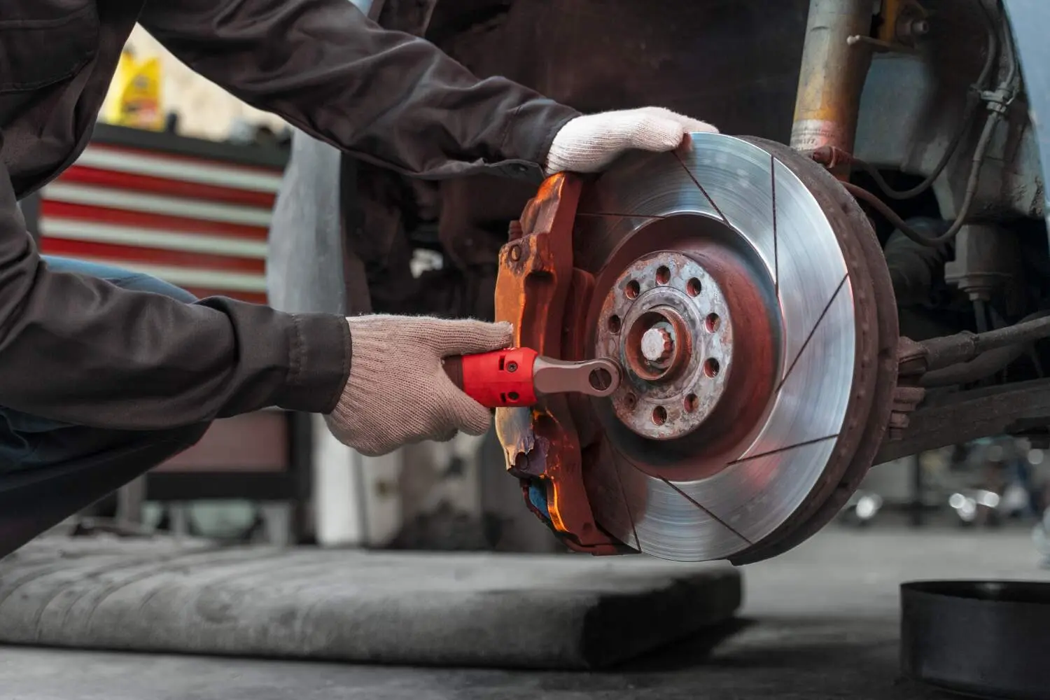  Mechanic repairing and inspecting car brake disc and caliper at Al Ali Al Khateeb Workshop in Kuwait.