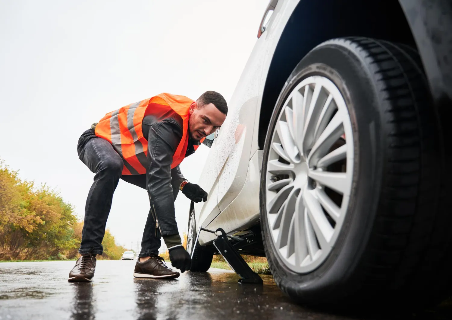  Mechanic providing mobile car repair service in Kuwait with roadside tire assistance.